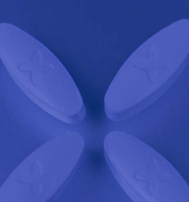 A blue background and 4 white oval Boquet suppository pills in a criss cross position in the center