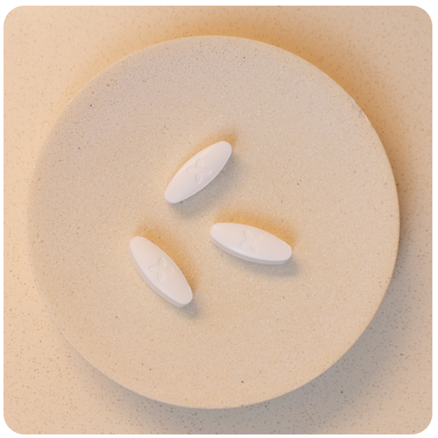 A natural terracotta plate with 3 Boquet white oval pills in the middle